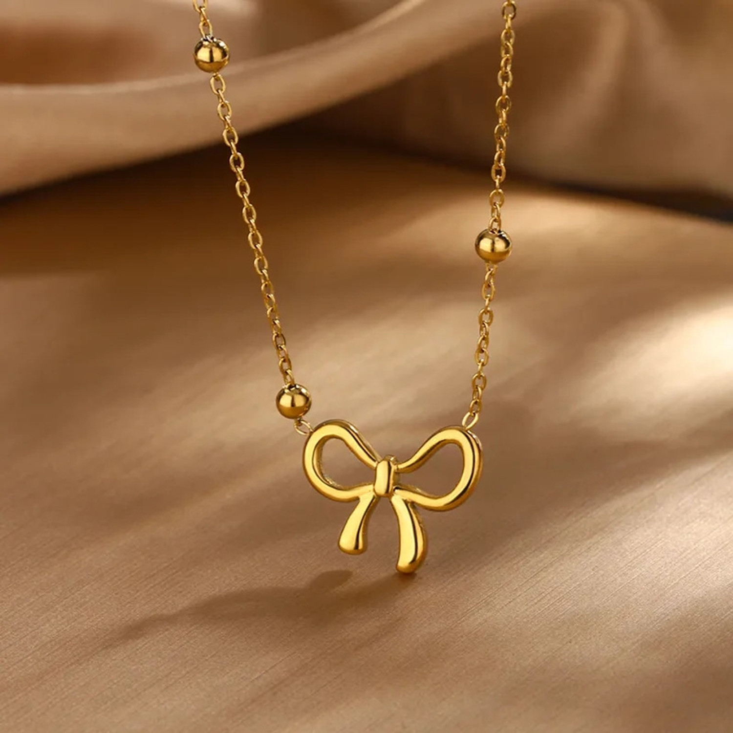 Image of alinora jewels Golden Plated Anti Tarnish Bow Charm 3PC Set Gold-plated Stainless Steel Pendant Set