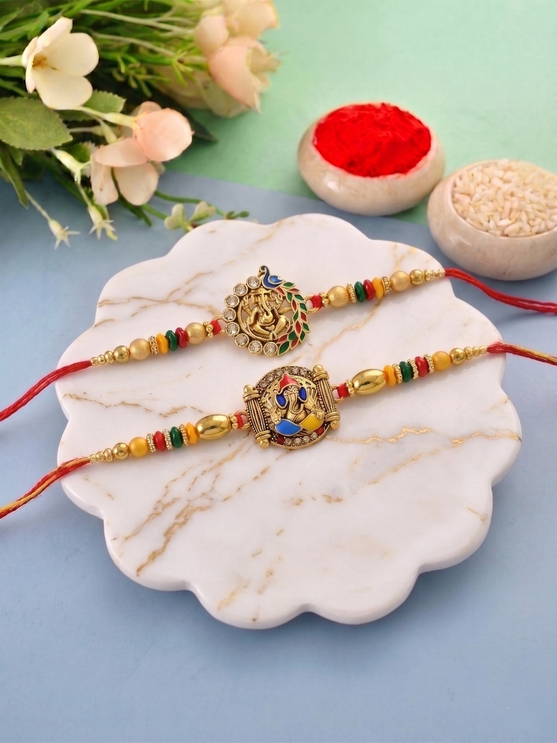 Image of Bhaiya Bhabhi Brass Elegant Ganesha Combo Rakhi for Brother Kids 147 Mauli Thread, Gold Finish, Pearl, Silver Rakhi, Greeting Card, Chawal Roli Pack Set by Meira Jewellery