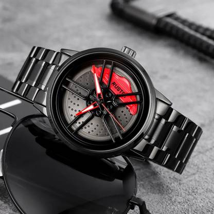 The watch resting on a dark surface, showing the full black bracelet